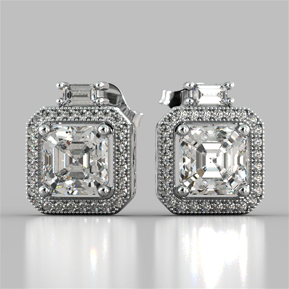 Pair of diamond earrings on a reflective surface with a light gray background