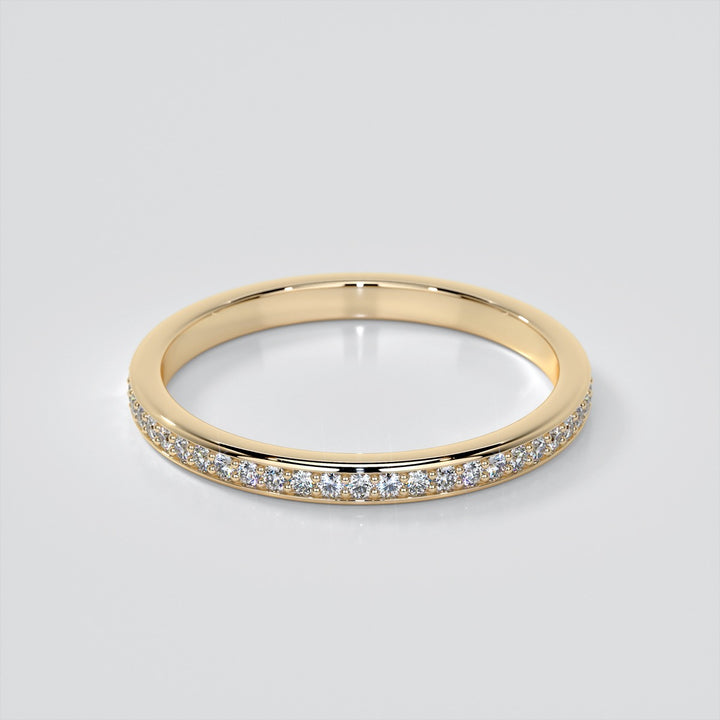 Gold ring with small diamonds on a light gray background