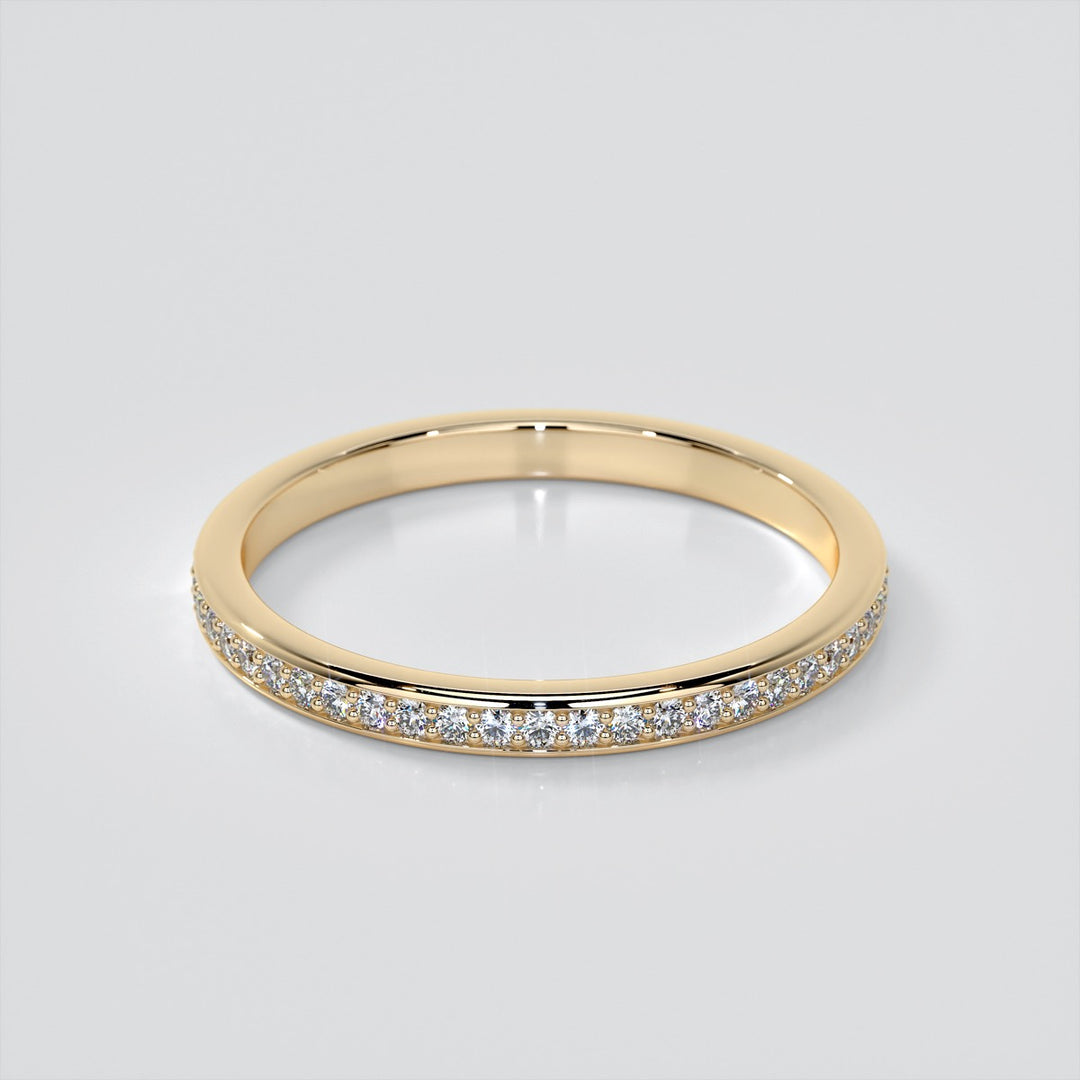 Gold ring with small diamonds on a light gray background