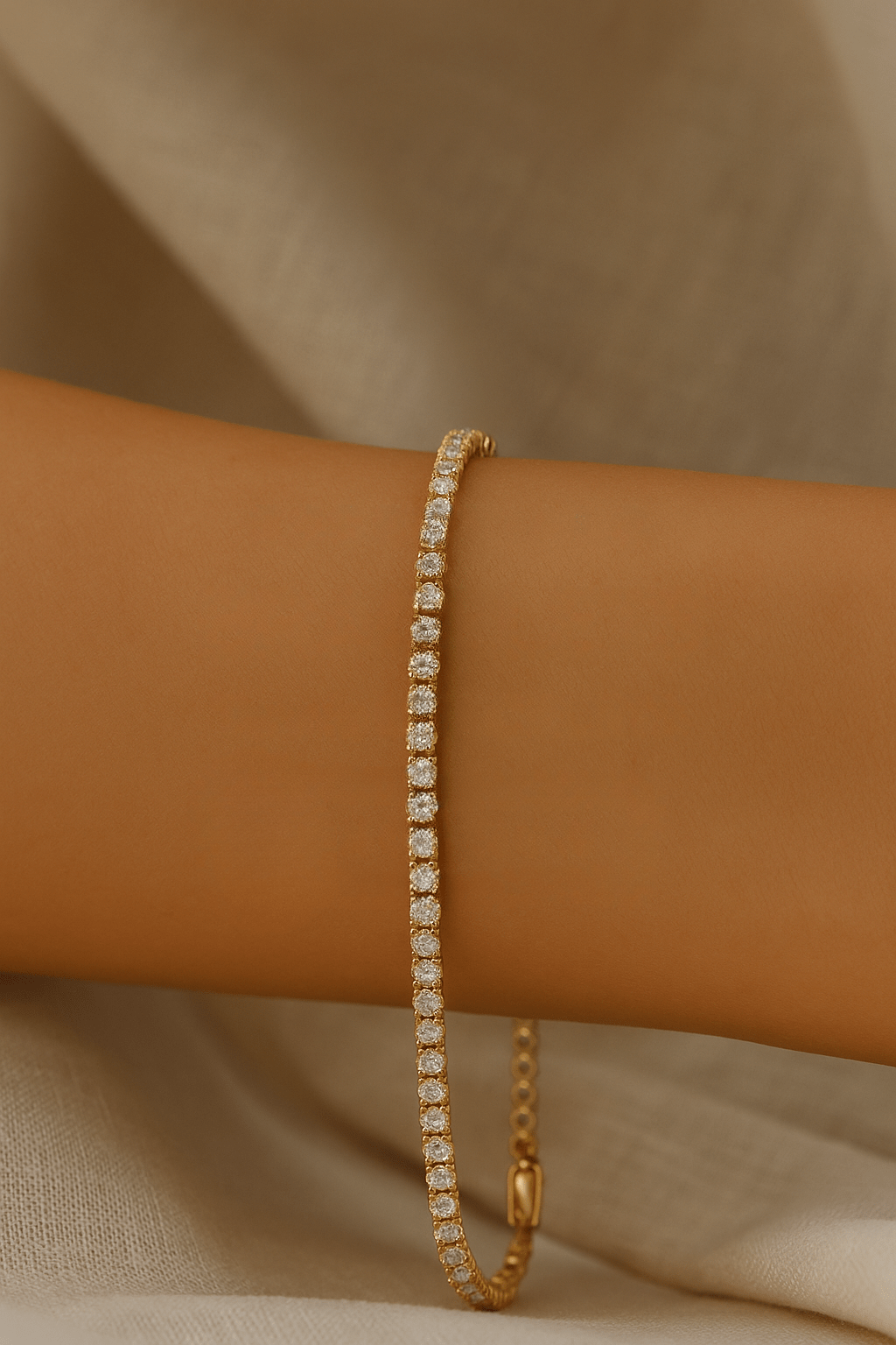 Gold bracelet with diamonds on a wrist against a neutral background