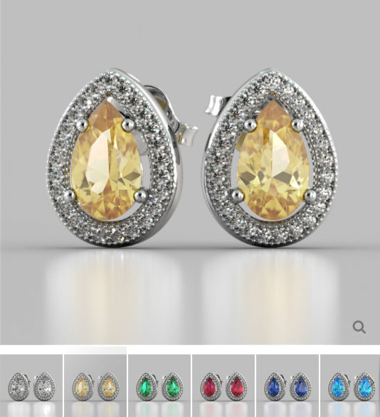 Pair of earrings with yellow gemstones on a gray background