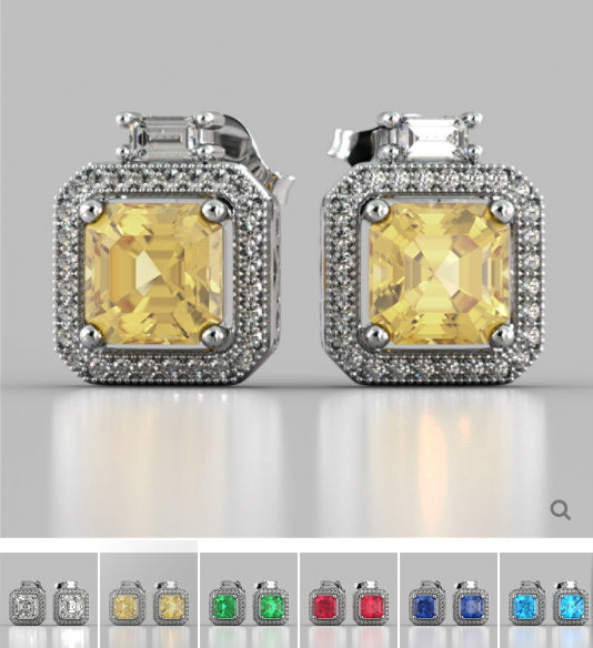 Pair of earrings with yellow gemstones and silver frames on a gray background.