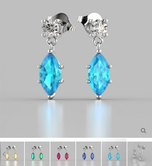 Pair of earrings with blue gemstones on a gray background