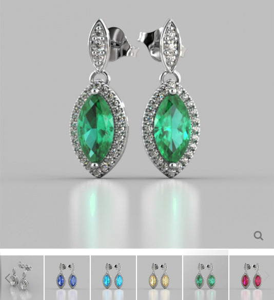 Pair of emerald green earrings with silver accents on a gray background