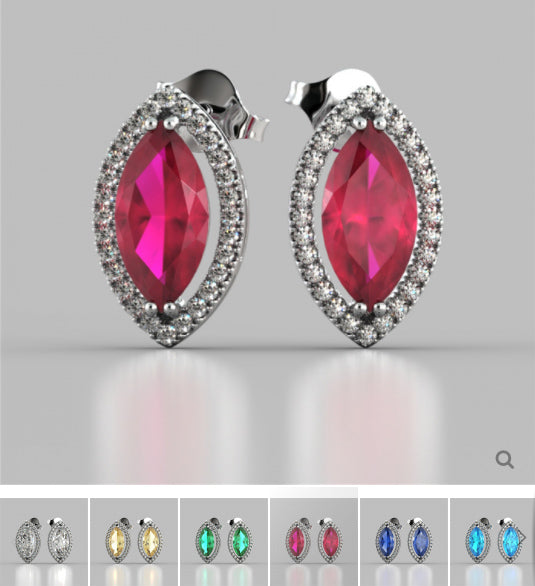Pair of earrings with red gemstones and silver settings on a gray background