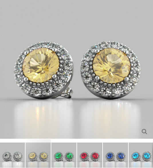 Pair of earrings with yellow gemstones and silver surrounds on a light gray background.