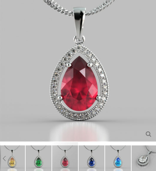 Teardrop-shaped red gemstone pendant with silver frame on a gray background