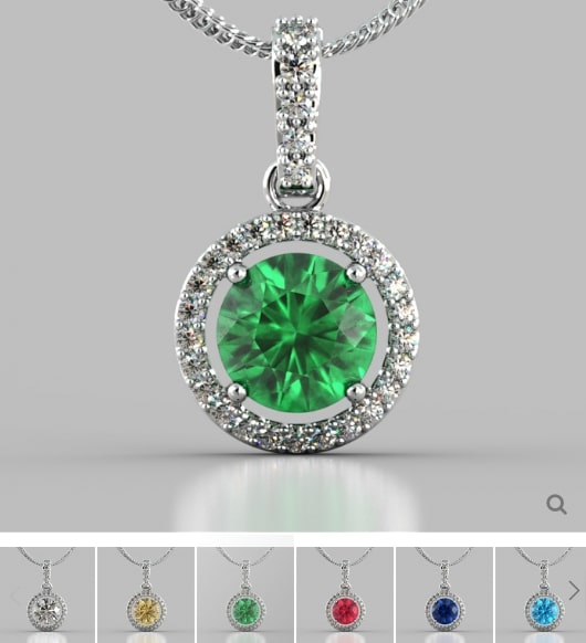 Green gemstone pendant with silver chain on a gray background