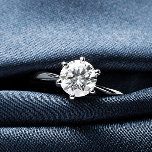 Diamond ring on a blue denim fabric background