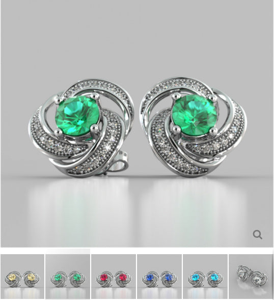 Pair of silver earrings with green gemstones on a gray background